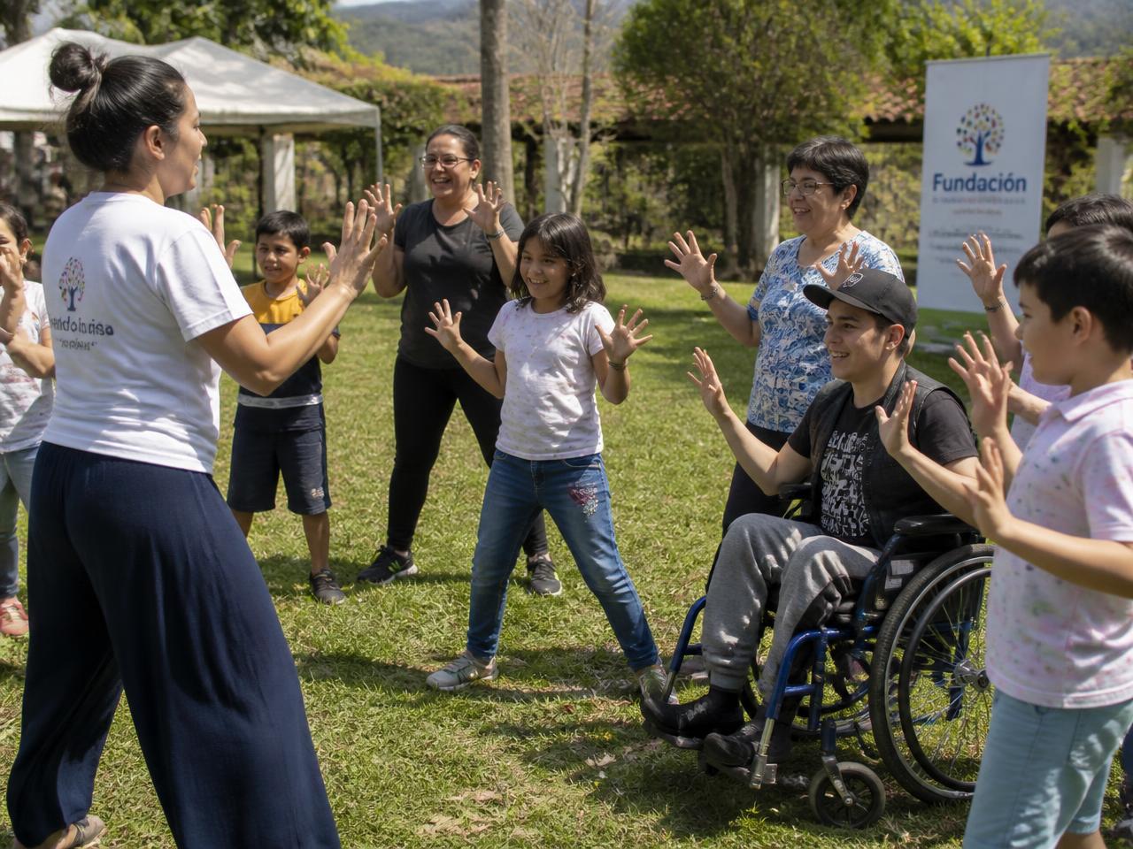 Facilitadora guiando una dinámica recreativa inclusiva al aire libre con niños y una persona en silla de ruedas